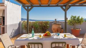 einen weißen Tisch mit einer Obstschale auf einer Terrasse in der Unterkunft Casa Balcon de la Axarquia Almachar by Ruralidays in Almáchar