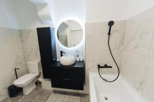 Un baño con lavabo, inodoro y espejo. en Cozy 2-Room Apartment - Free Parking - Close to Airport, en Apahida