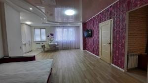 ein Schlafzimmer mit einem Bett und einer rosa Wand in der Unterkunft 2 кімнатна квартира на Садовому in Shcherbani