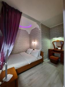 ein Schlafzimmer mit einem großen Bett mit einem lila Vorhang in der Unterkunft 2 кімнатна квартира на Садовому in Shcherbani