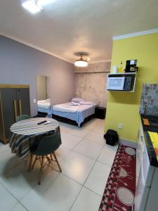 a small room with a bed and a table with a chair at Pousada Confort in Sao Paulo