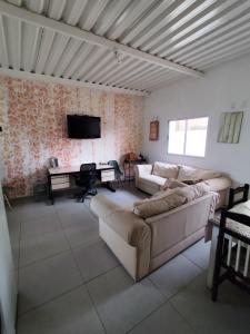 a living room with two couches and a piano at Pousada Confort in Sao Paulo
