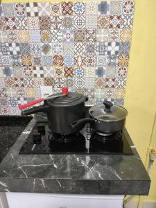 two pots on top of a stove in a kitchen at Pousada Confort in Sao Paulo