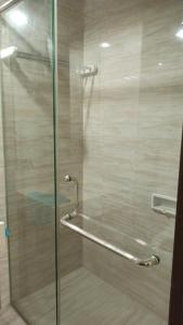 a shower with a glass door with a metal handle at Ruby Apartment #29 in Yogyakarta