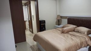 a bedroom with a large bed and a mirror at Ruby Apartment #29 in Yogyakarta