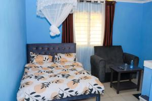 ムトワッパにあるMtwapa Empire Holiday Apartmentsのベッドと椅子のある青い寝室
