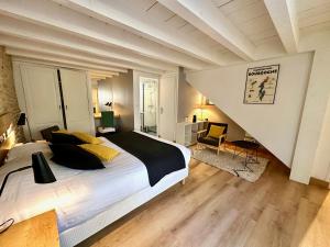 een slaapkamer met een groot bed en een trap bij Clos de Fougères - Cocon in Montoillot