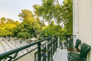 a balcony with green chairs and trees and trees at VIP Apartment in Nizami street Downtown in Baku