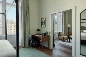 a hotel room with a desk and a bed and a bedroom at Miiro Palais Rudolf in Vienna