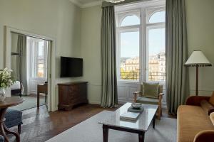 a living room with a couch and a tv at Miiro Palais Rudolf in Vienna
