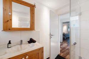 ein Badezimmer mit Waschbecken, Spiegel und Dusche in der Unterkunft Forest Apartment - Renchen in Unterberg + 27 Fotos