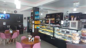 a bakery with tables and a display case with pastries at Pousada Ilha do Itacolomi Com Piscina Proximo do Beto Carrero in Penha