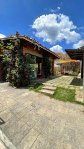 un edificio con una planta delante en Café e Pousada Jardim Secreto, en Santa Rita do Sapucaí