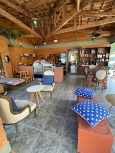 un restaurante con sillas y mesas en una habitación en Café e Pousada Jardim Secreto, en Santa Rita do Sapucaí