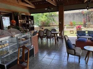 Un hombre en un restaurante con mesas y sillas. en Café e Pousada Jardim Secreto, en Santa Rita do Sapucaí 69 fotos más