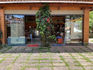 un edificio con una planta a un lado en Café e Pousada Jardim Secreto, en Santa Rita do Sapucaí