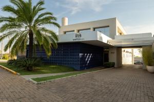 um prédio com uma palmeira na frente em Morada Inn Hotel em Franca