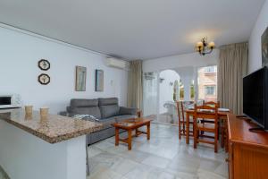 Sunstay Relax Rio Marina Beach Nerja في نيرخا: غرفة معيشة بها أريكة وطاولة
