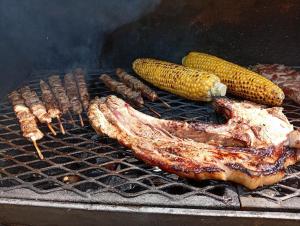 un grupo de carnes y maíz en una parrilla en Ipsario Garden Hotel, en Skala Potamias
