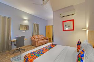 a bedroom with a bed and a chair and a desk at FabHotel The Vibe - Nr SR Nagar Metro Station in Hyderabad