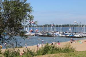 a group of people on a beach near a marina at MY-A-Mi-Go-S in Muiderberg