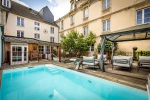 a swimming pool in front of a building at Grand Hôtel du Luxembourg & Spa in Bayeux