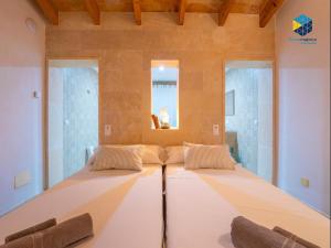 ein großes Bett in einem Zimmer mit 2 Stühlen in der Unterkunft Finca rural S'Art 9 in Ses Salines