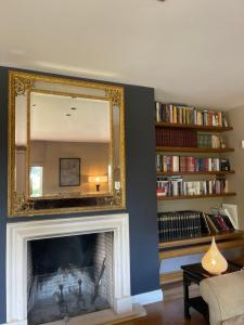 een woonkamer met een open haard en een spiegel erboven bij Slow living beautiful villa in Rafina