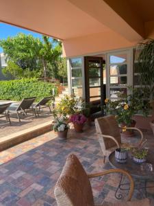 een patio met stoelen en een tafel met planten bij Slow living beautiful villa in Rafina