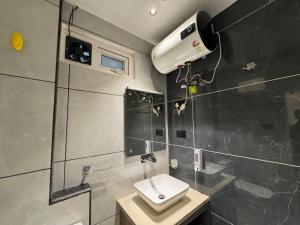 a bathroom with a toilet and a sink and a fan at Hotel La Sera in Srinagar