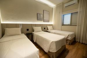 um quarto com duas camas e uma janela em Morada Inn Hotel em Franca mais 28 fotografias