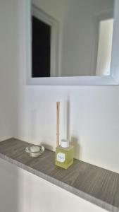 a bathroom counter with a yellow box and a mirror at VitruApart Temporario in Resistencia
