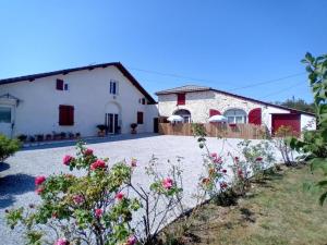 a white house with flowers in front of it at Gite tafan in Pouillon