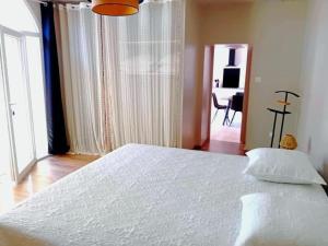 a bedroom with a large white bed and a desk at Gite tafan in Pouillon +12 photos