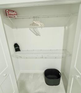 フロリダシティにあるThe serene suiteの棚と黒いスツールが付いた白いクローゼット