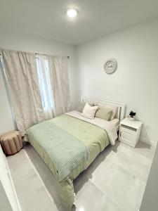 フロリダシティにあるThe serene suiteのベッドと窓のある白い寝室