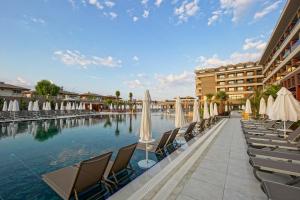 a pool at a resort with chairs and umbrellas at Aletris Deluxe Hotel & SPA in Side