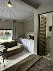 a bedroom with a bed and a couch and a table at A melhor localização de Belém do Pará in Belém