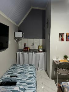 a room with a kitchen with a table and a bed at A melhor localização de Belém do Pará in Belém