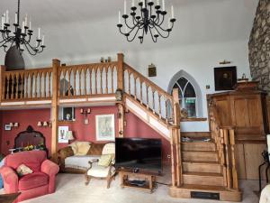 a living room with a staircase and a tv at Kilfinichen Church in Kilfinchen