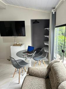 a living room with a couch and a table with a laptop at A melhor localização de Belém do Pará in Belém
