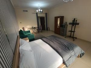 a bedroom with a bed and a chair in it at ApartHotel Rooms in Ajman 
