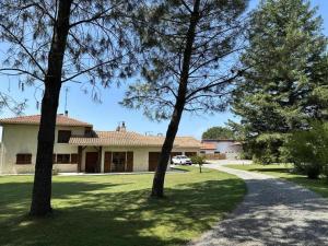 a house with trees in front of a driveway at La lande in Pontonx-sur-lʼAdour