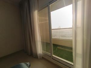 a room with a window with a view of the ocean at ApartHotel Rooms in Ajman 