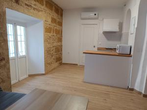 eine weiße Küche mit einer Theke und einer Mikrowelle in der Unterkunft El rinconcito de Bruno in Arcos de la Frontera