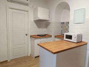 eine Küche mit weißen Schränken und einer Mikrowelle auf der Theke in der Unterkunft El rinconcito de Bruno in Arcos de la Frontera + 2 Fotos