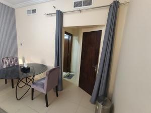 a room with a table and a chair and a door at ApartHotel Rooms in Ajman 