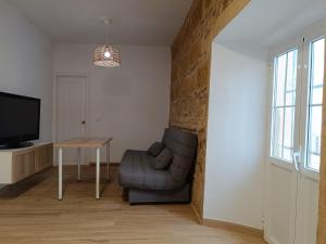 ein Wohnzimmer mit einem Stuhl und einem Tisch in der Unterkunft El rinconcito de Bruno in Arcos de la Frontera