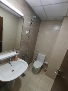a bathroom with a sink and a toilet and a mirror at ApartHotel Rooms in Ajman 