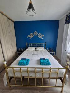une chambre avec un lit avec un mur bleu dans l'établissement Cosy la Riveraine Cottage, à Saint-Aignan